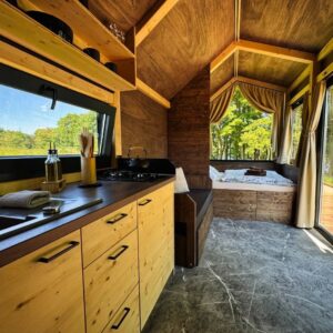 Zahradní bydlení – obývací prostor v tiny housu od Woodky.cz s praktickým uspořádáním.