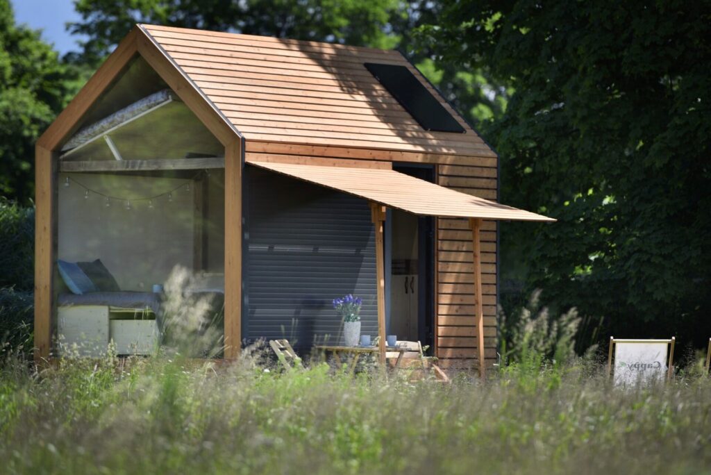 Zahradní domky – stylový dřevěný Tiny House umístěný uprostřed zelené zahrady.